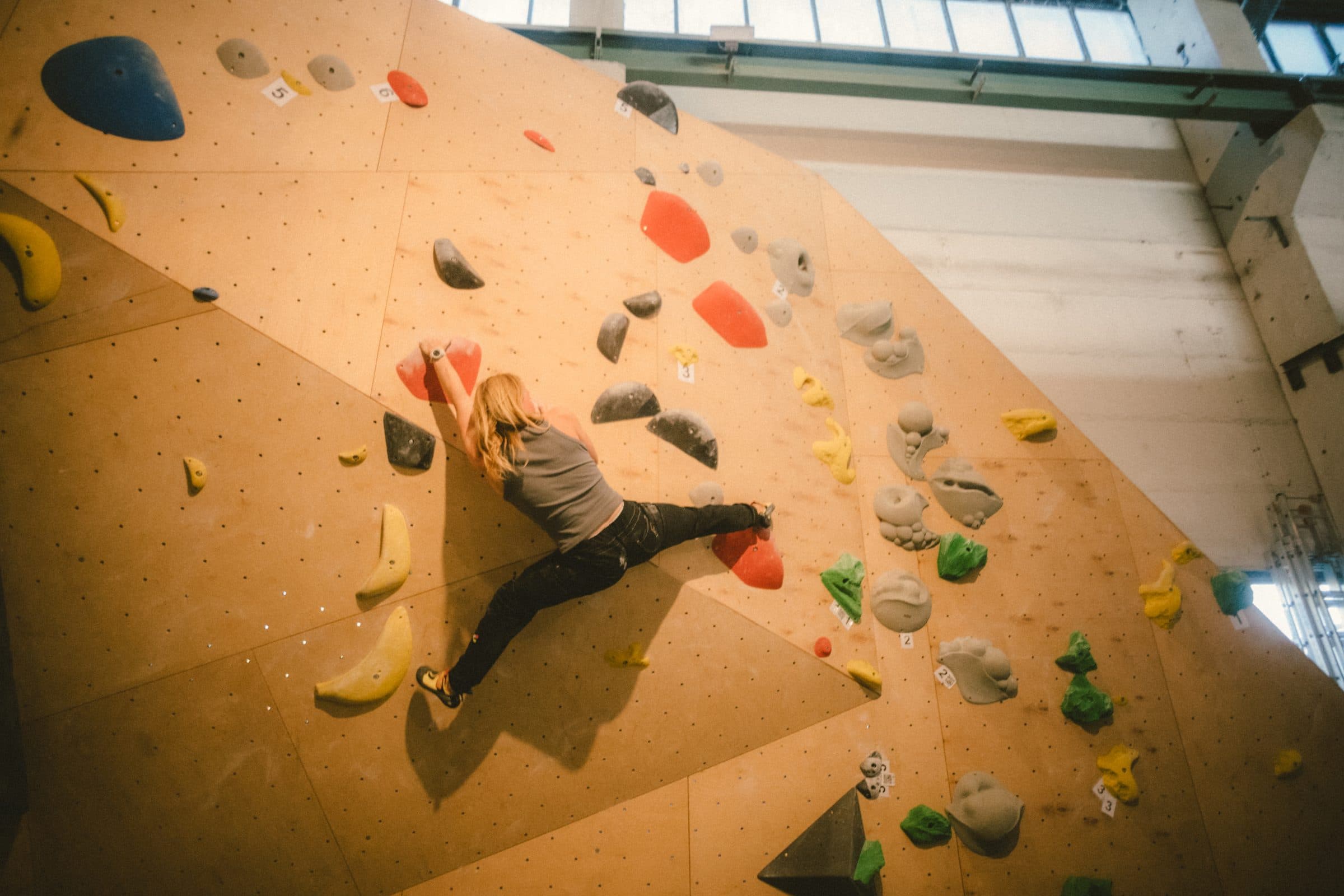 Boulderin an einer Platte voller bunter Griffe