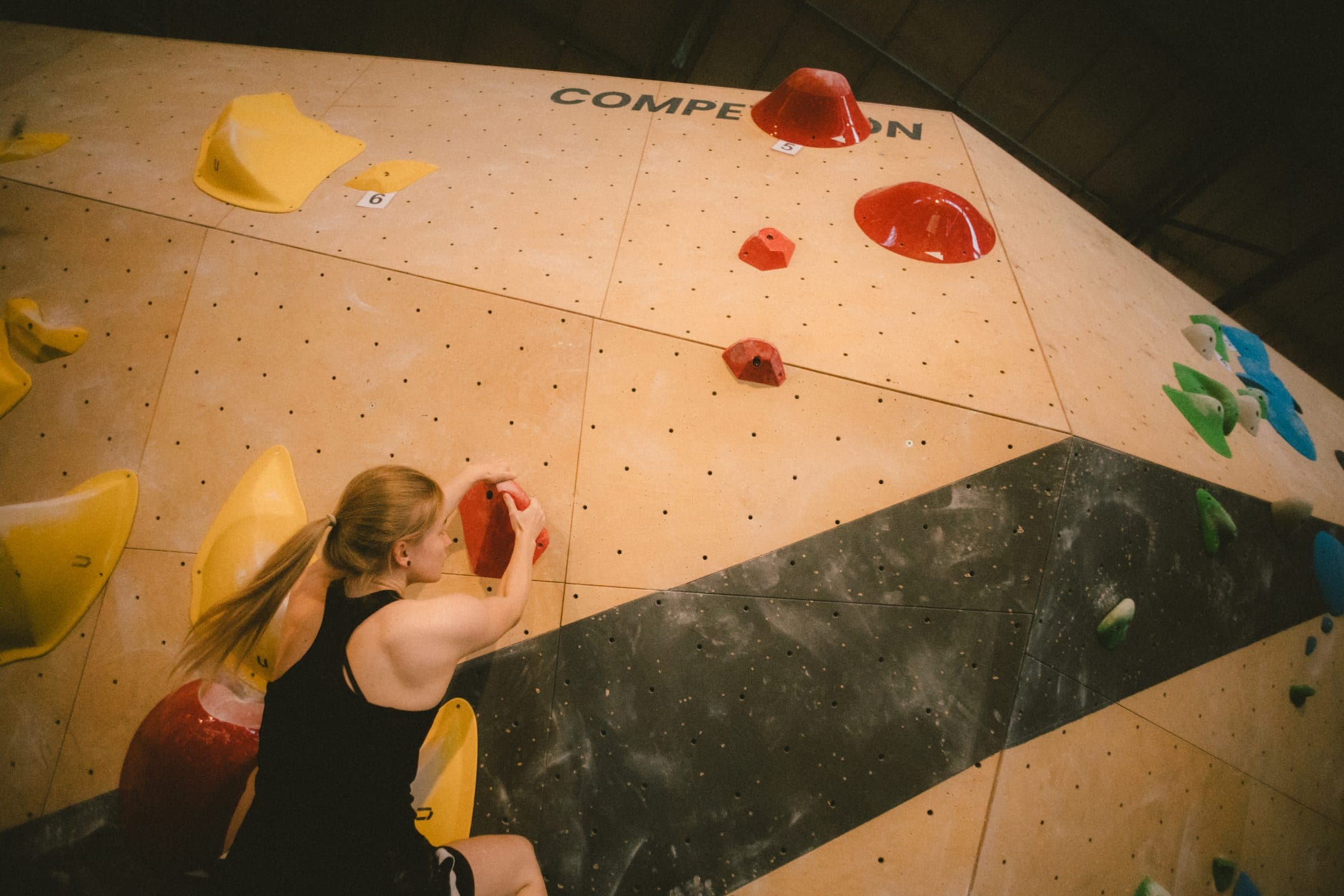Boulderin an der Competition-Wand zwischen roten und gelben Griffen