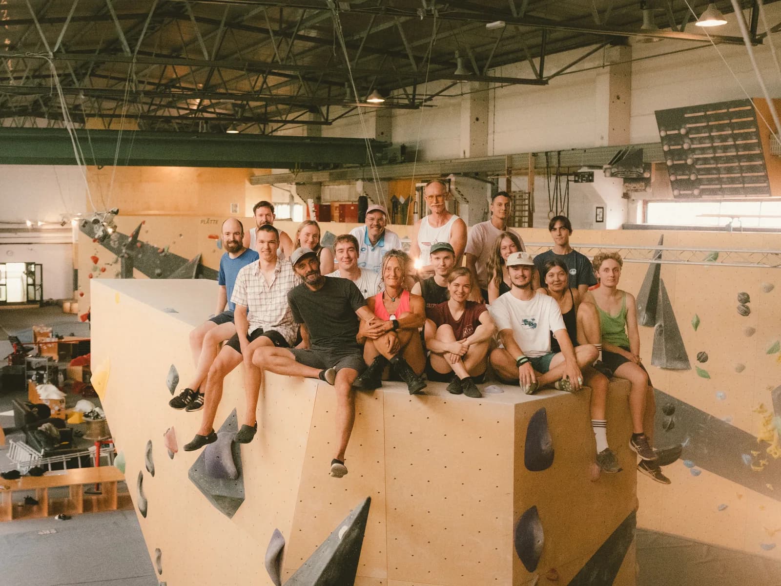 Das Grips-Team sitzt nebeneinander auf einem Boulderblock in der Halle